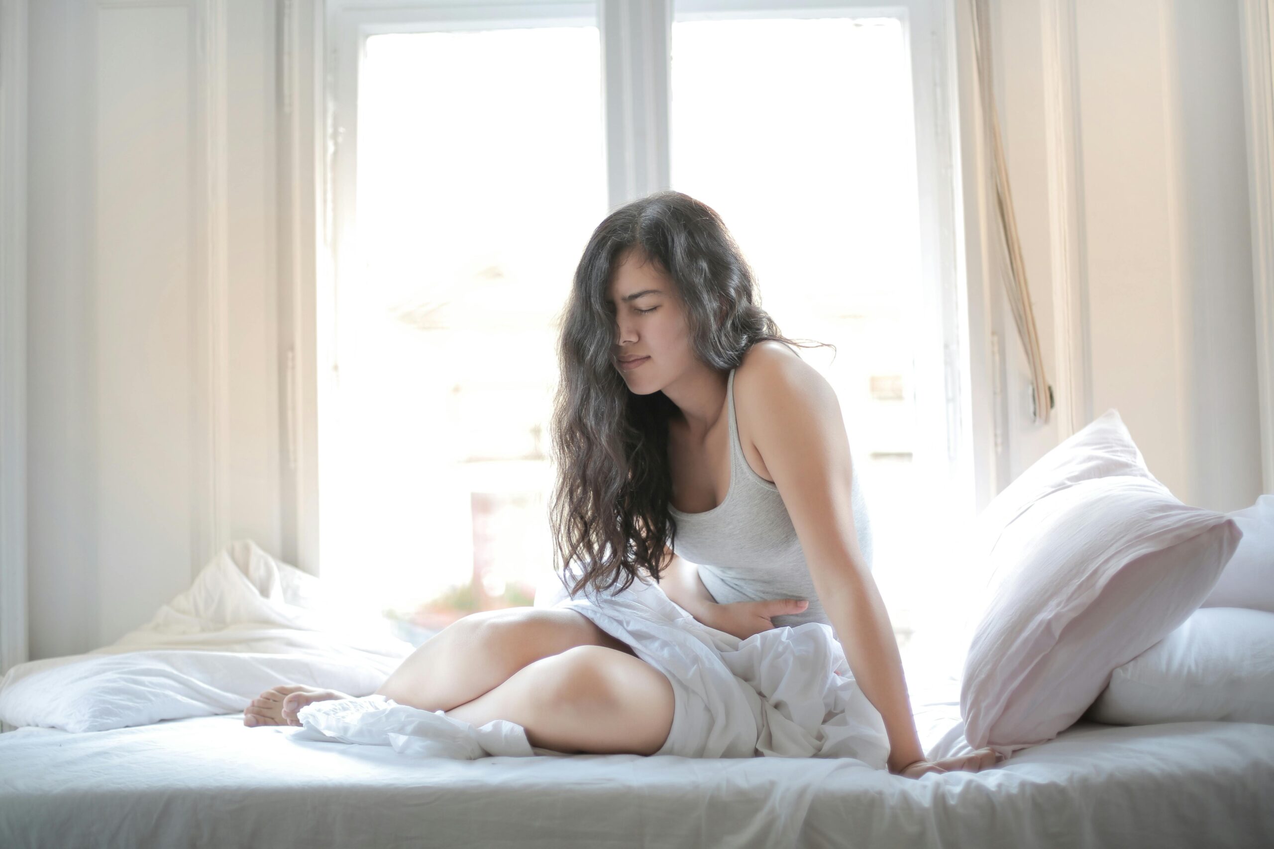gut liver connection bloating woman holding stomach