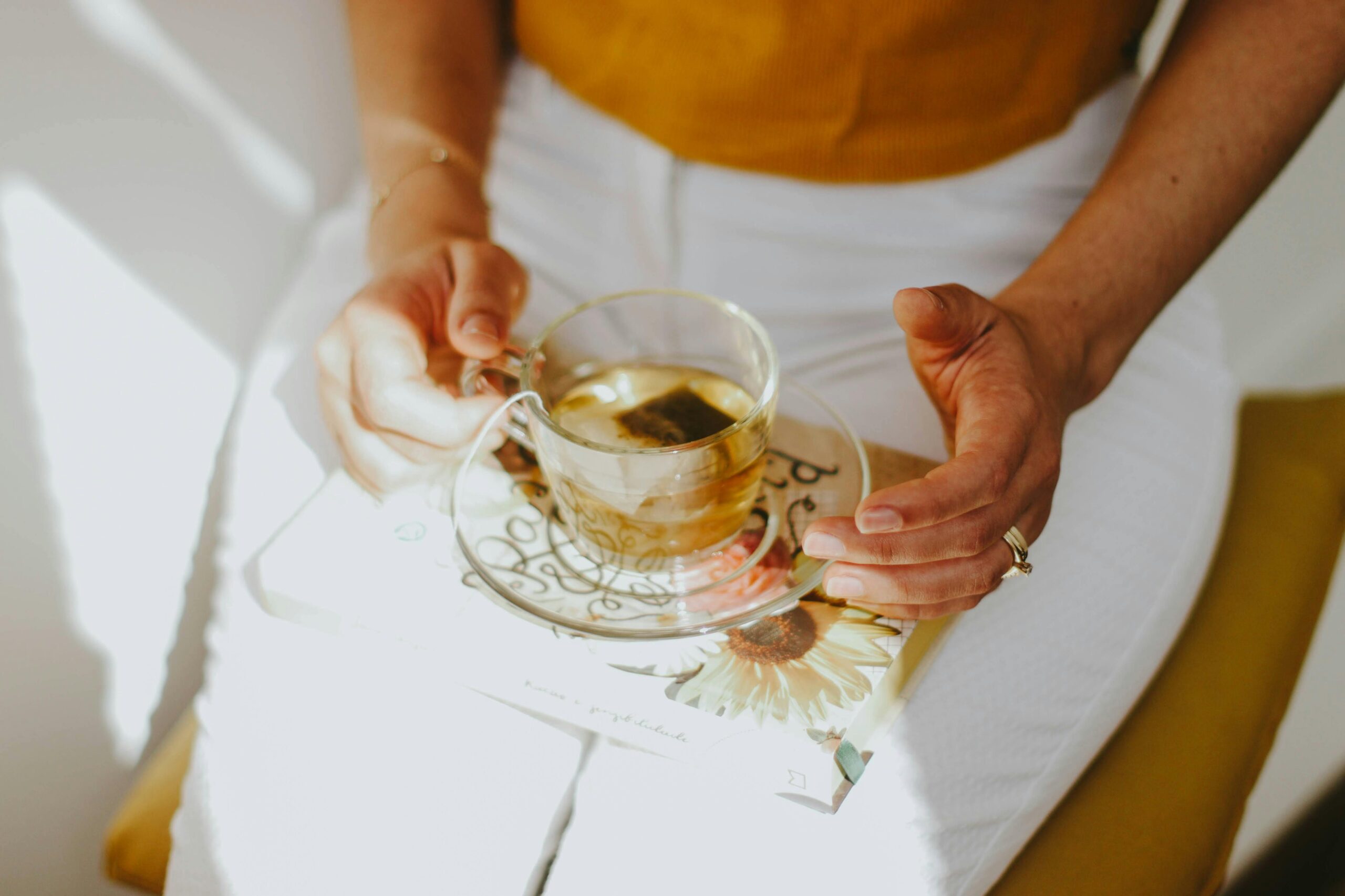 how to reduce bloating naturally, woman relieving bloating with herbal remedy