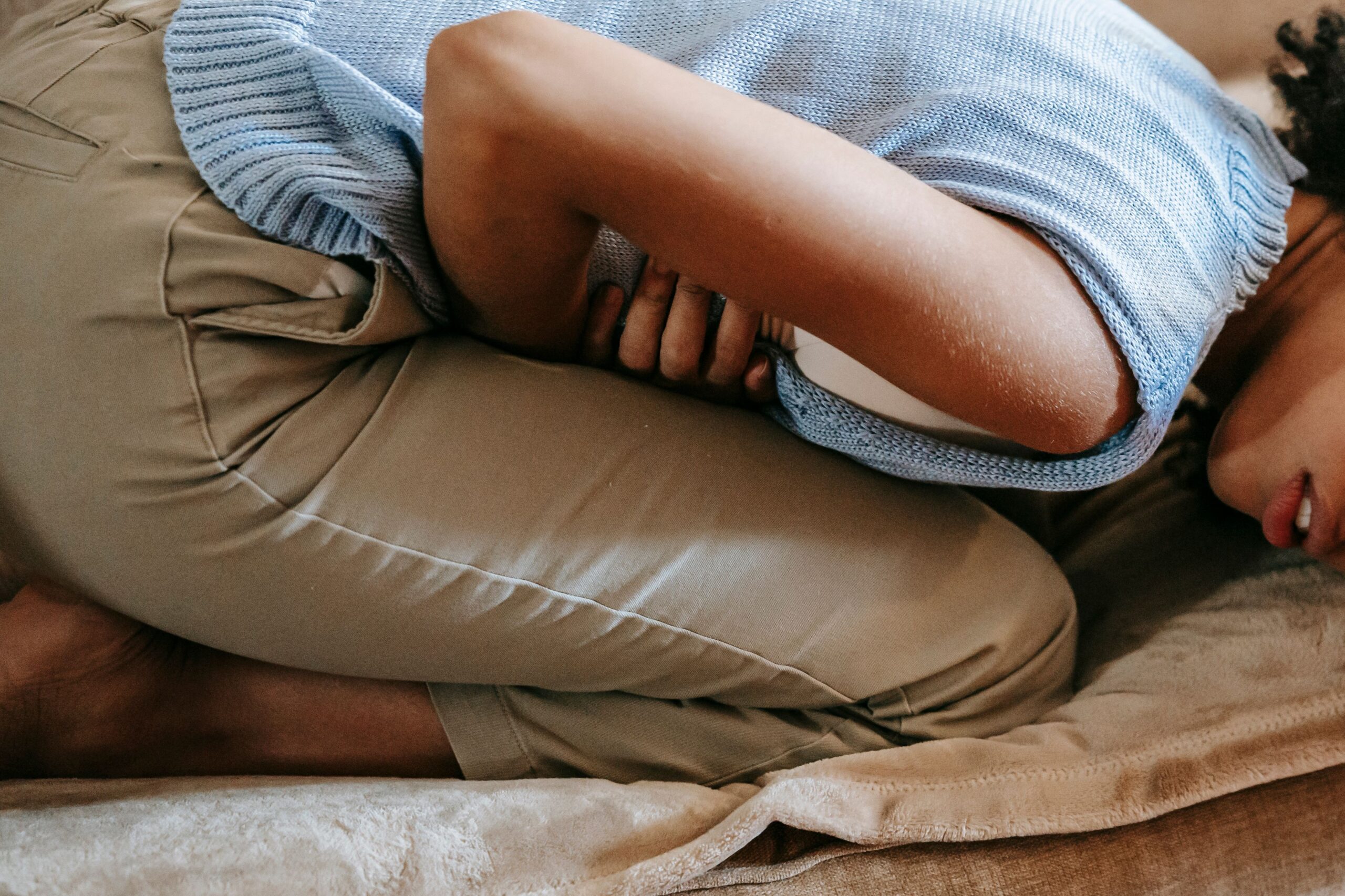 Woman lying down with hormonal bloating before period