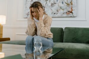 Woman experiencing IBS bloating symptoms holding her head