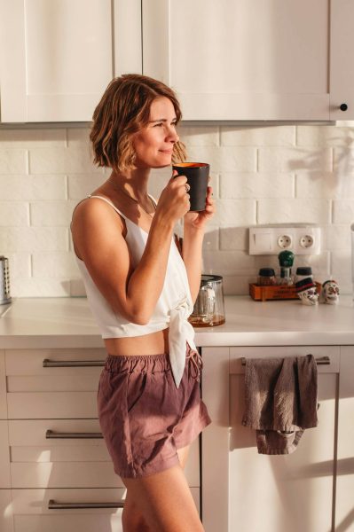 Woman in kitchen seeking natural bloating relief